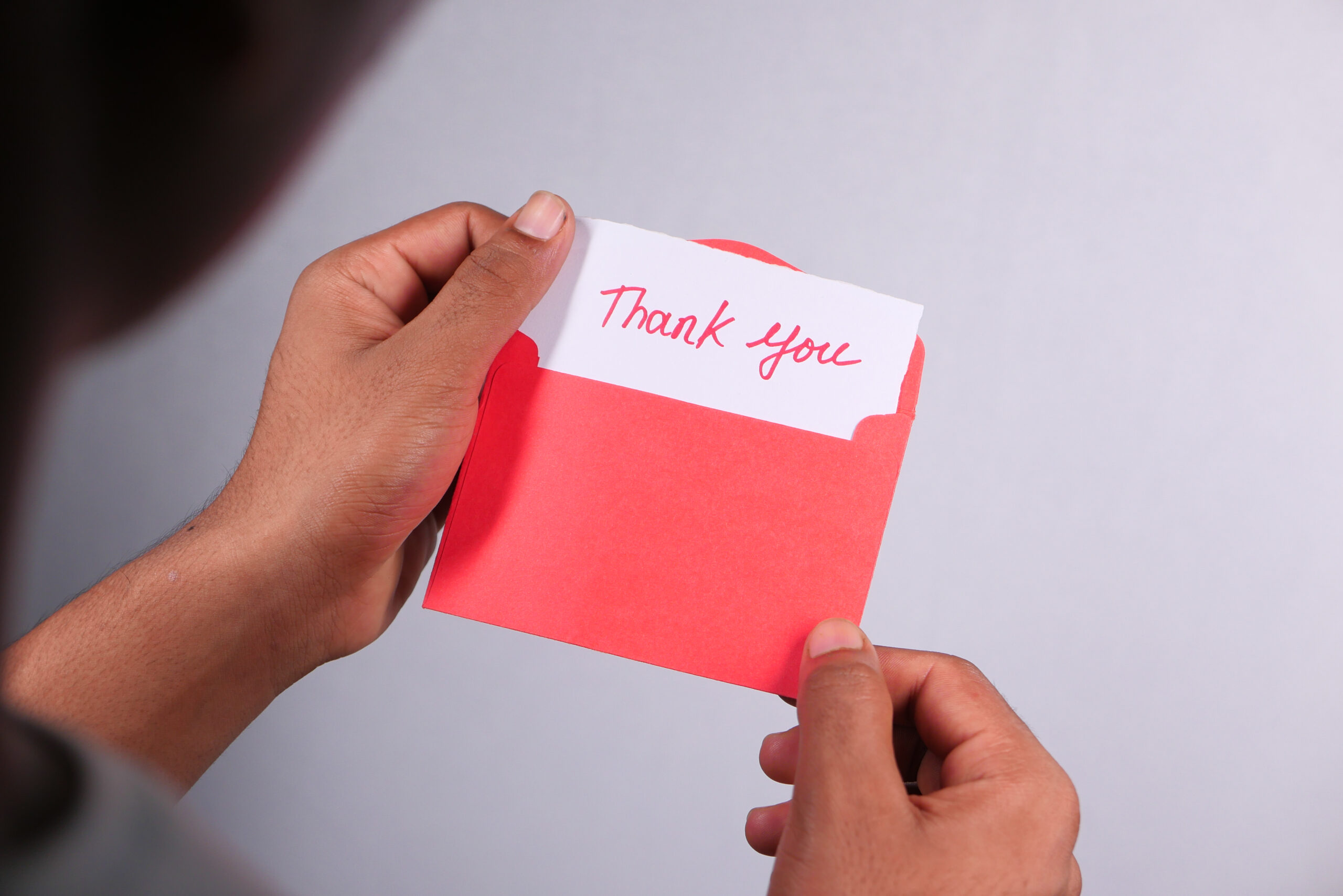 Close up of a window treatment installer hand reading a thank you letter